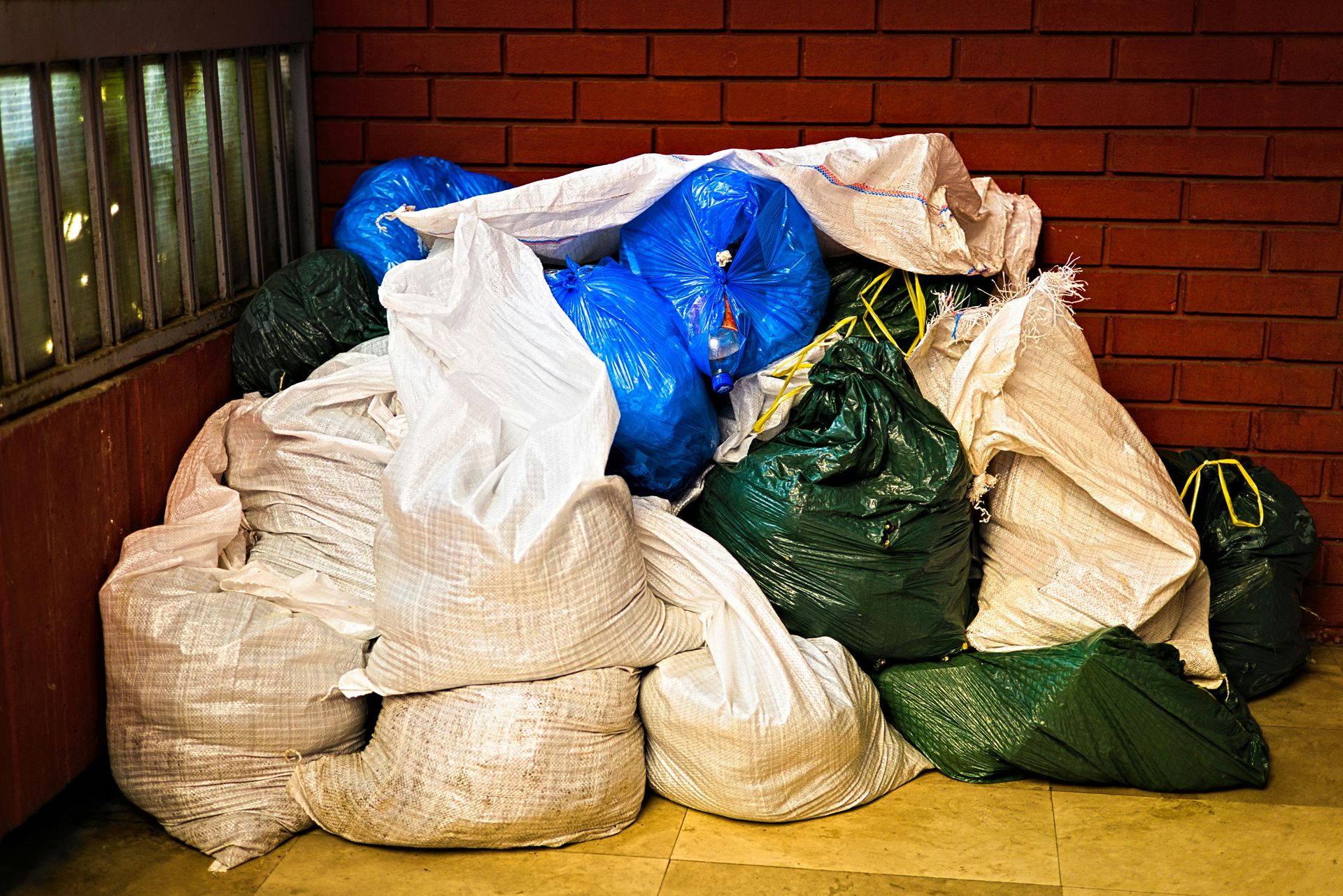 A pile of garbage sitting next to a brick wall
